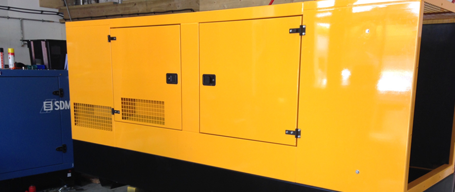 Yellow standby power generator that has had its canopy repaired and painted.
