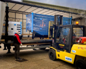 Standby diesel generator being unloaded by forklift from the back of a lorry