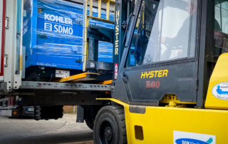 A Kohler-SDMO generator arrival being unloaded by forklift from the back of a lorry