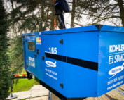 Kohler-SDMO generator being raised through trees outside a private residence. Residential generator install