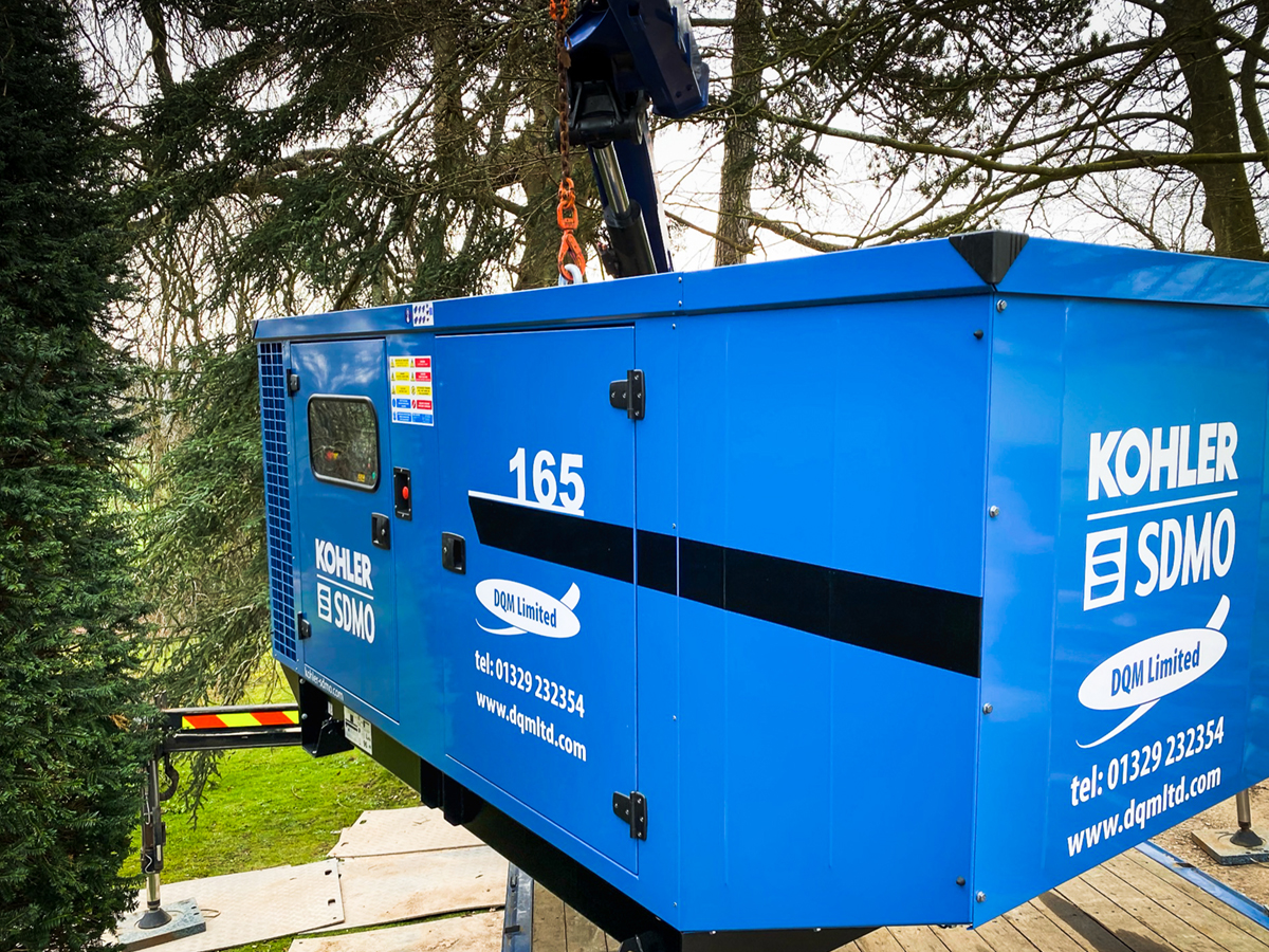 Kohler-SDMO generator being raised through trees outside a private residence