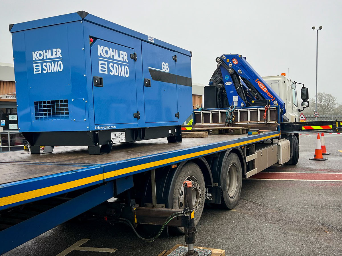 Kohler-SDMO 66kVA generator on the back of a flatbed trailer ready to be offloaded. Motorway depot generator install