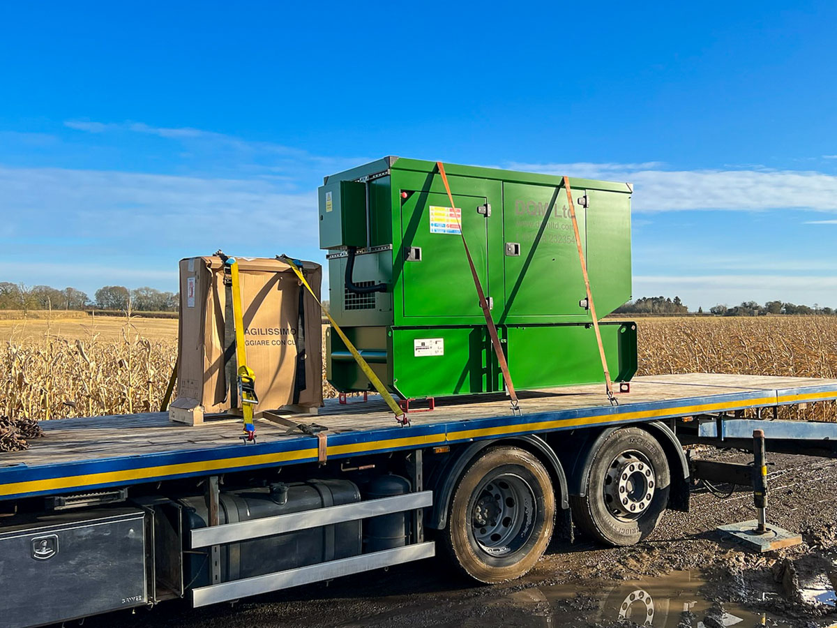 Custom colour 110kVA Kohler-SDMO generator on back of a flatbed ready for unloading at a rural residence. Residential generator install