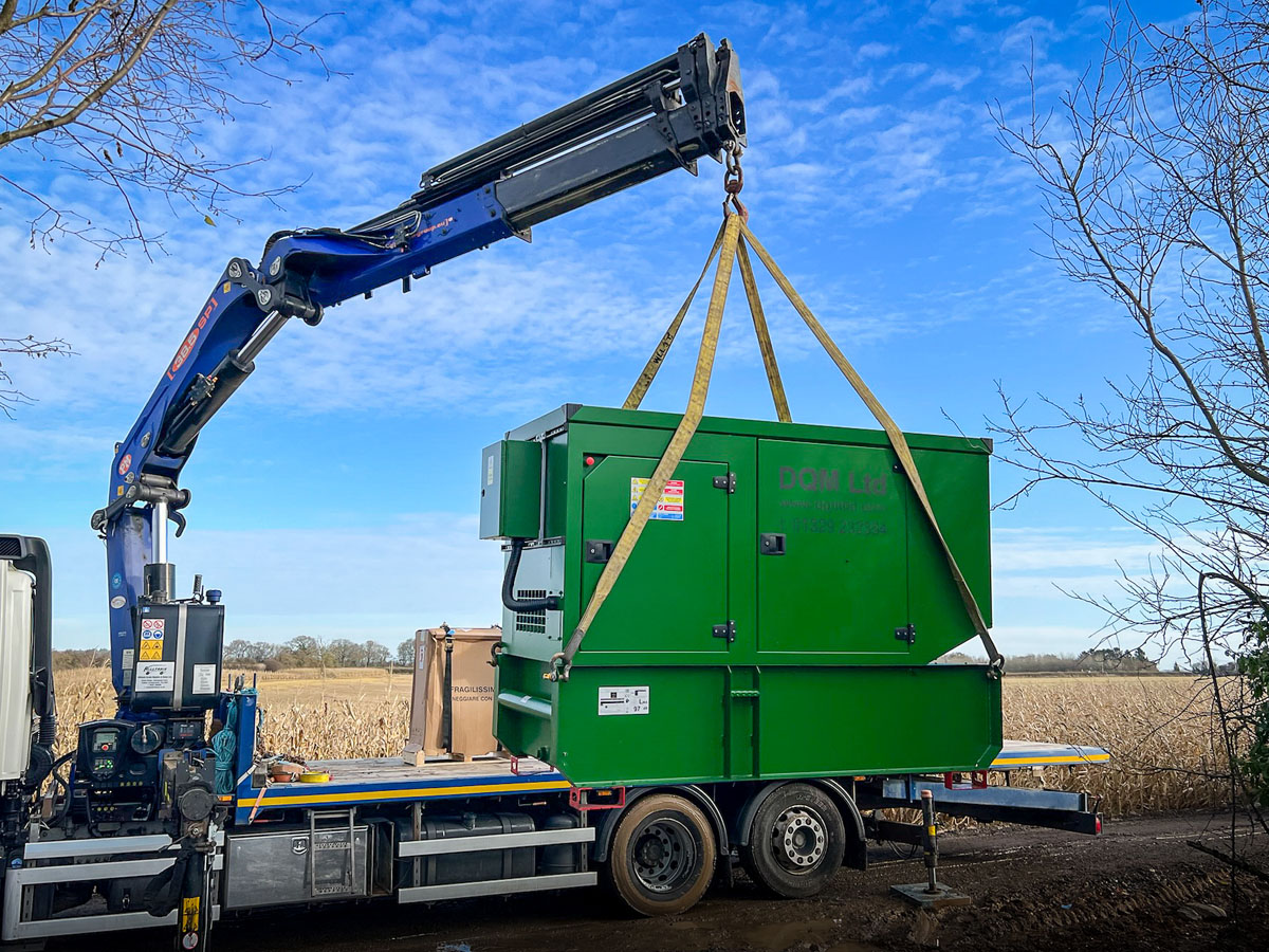 Custom colour 110kVA Kohler-SDMO generator being offloaded from back of a flatbed ready for installation at a rural residence. Residential generator install