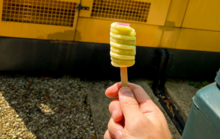 Twister ice lolly raised in front of a yellow generator